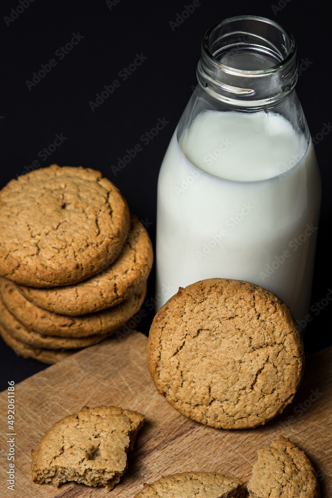 Oatmeal cookies with a bottle of milk on a black background. Light and tasty dessert. Healthy breakfast Oatmeal cookies with a bottle of milk on a black background. Light and tasty dessert. Healthy breakfast
