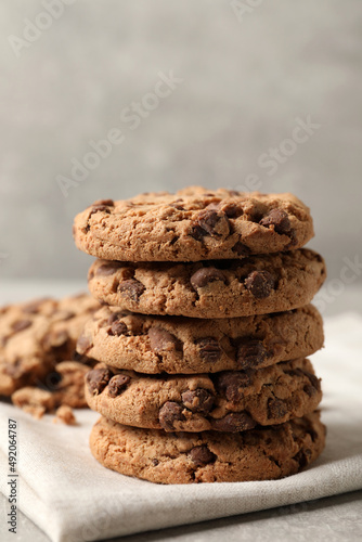 Delicious chocolate chip cookies on light grey table