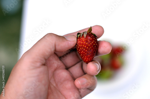 One strawberry in hand