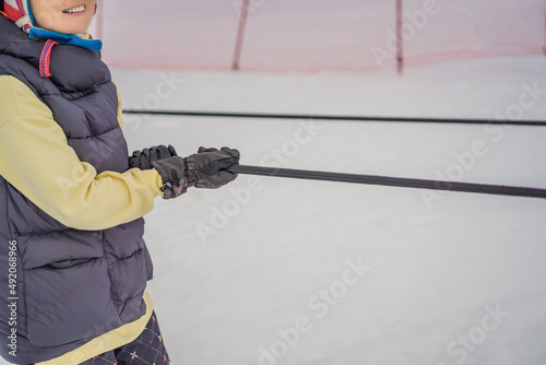 Woman skier climbs a mountain on a ski lift for beginners