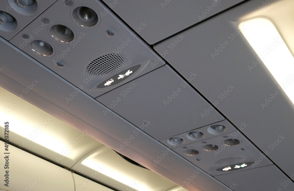 Plane interior before take-off with lit fasten seatbelt and no smoking sign Plane interior before take-off with lit fasten seatbelt and no smoking sign