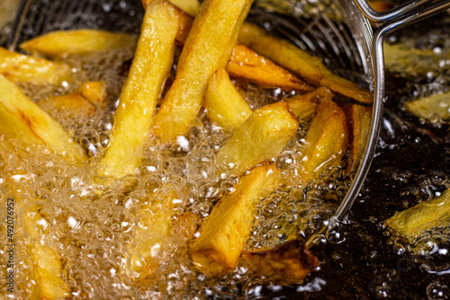 French fries. Making French fries in the fryer hot oil close up image.
