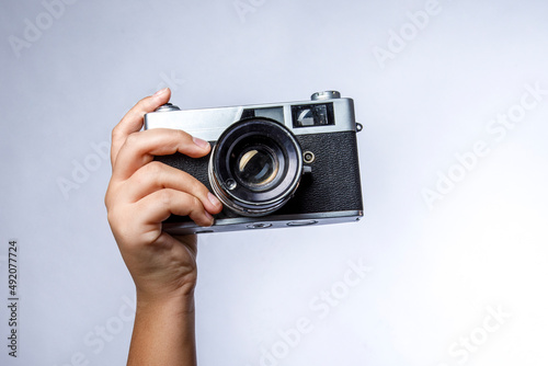 mano tiene macchina fotografica reflex vintage isolati su sfondo bianco