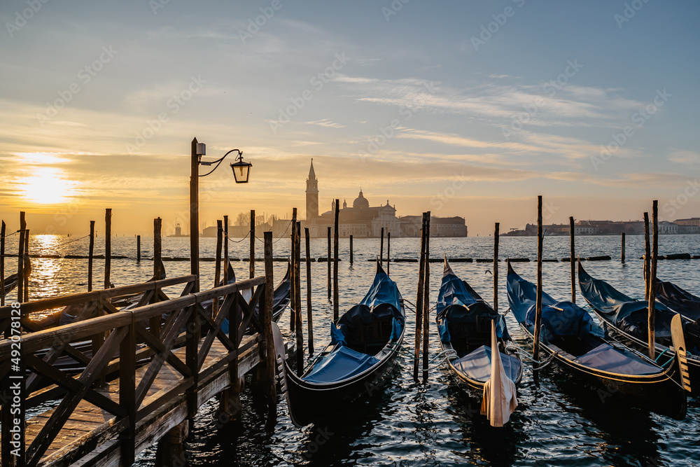 Venice,Italy.Famous canal and traditional gondolas,San Giorgio Maggiore church in background.Venetian city lifestyle,travel scenery.Architecture and landmark of Venezia.Water transport,sunny morning