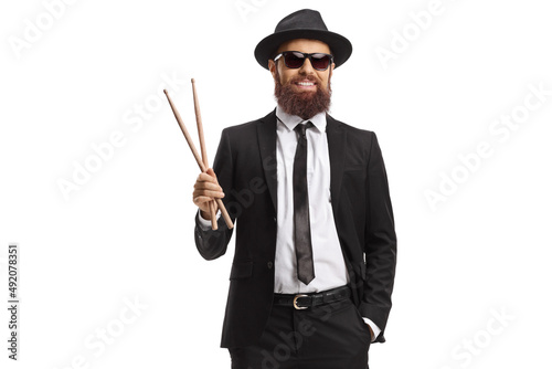 Man in a black suit holding a pair of drumsticks photo