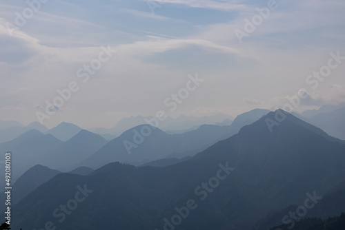 Scenic view on the alpine mountain chains of the Karawanks in Carinthia, Austria. Peaks are shrouded in morning fog. Mystical vibes. Clear and sunny day. Serenity. View from Ferlacher Spitze, Alps