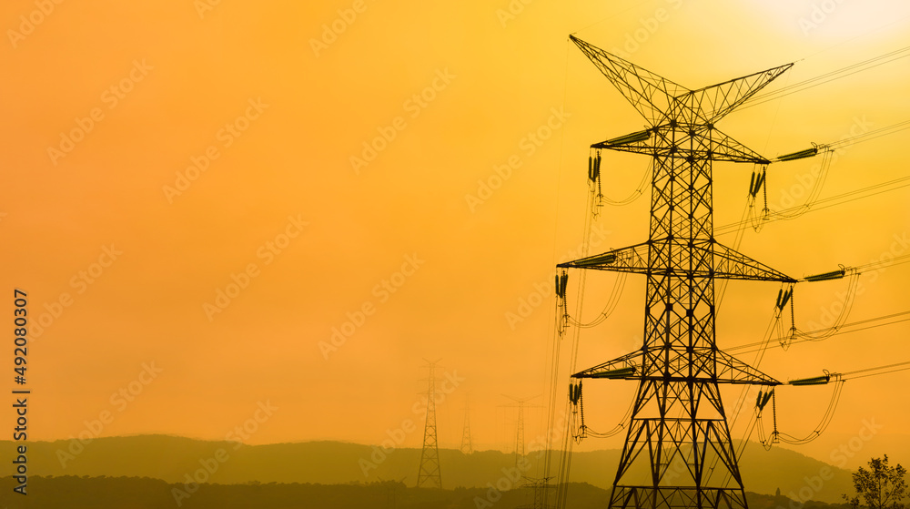 High voltage power lines at sunset. Silhouette of high voltage electricity transmission towers