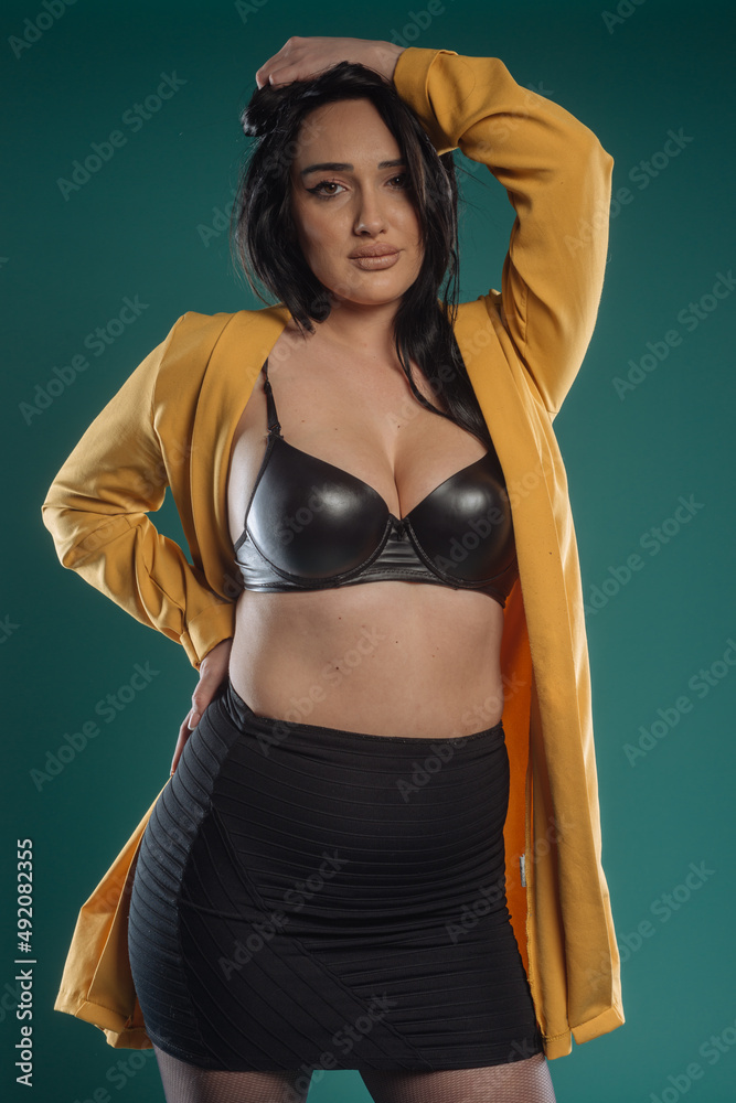 Plus size attractive sexy fashion model on green studio background, body positive concept. Plus size attractive sexy fashion model on green studio background, body positive concept.