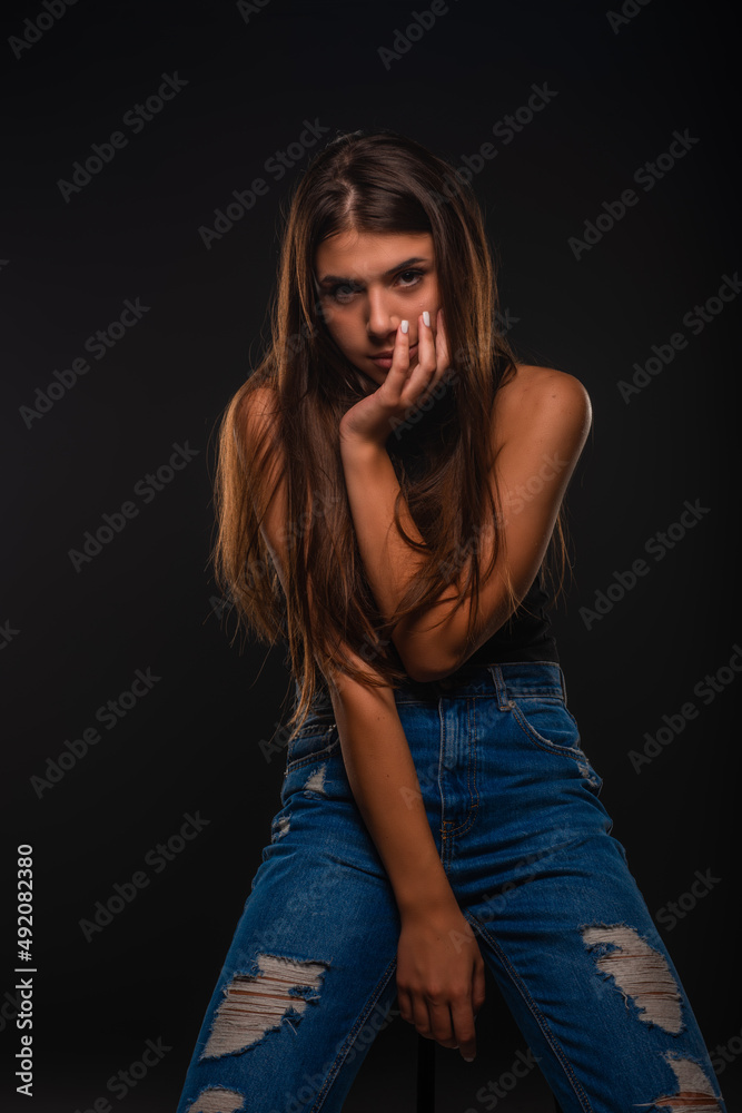 Posing while sitting on the chair in studio Posing while sitting on the chair in studio