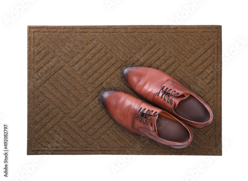 New clean door mat with shoes on white background, top view
