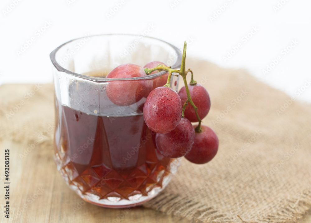 grapes with cup of wine isolated on wooden background grapes with cup of wine isolated on wooden background