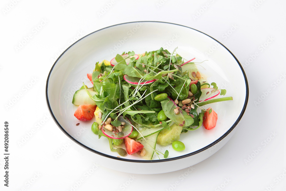 Salad of avocado, strawberries, cucumbers and lettuce leaves. Useful products. Vitamin salad.Healthy food. Isolated object. White background.Space for copying.Isolated object.