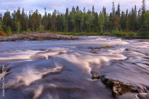 Northern landscape. Long exposure shot of rapid river on summer sunset. Murmansk Oblast, Russia.