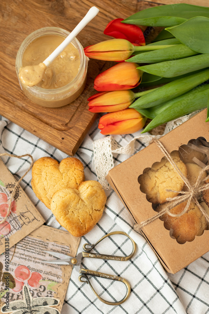 Peanut butter cookies with tulips. Crispy peanut butter cookies. Homemade vegan dessert. Vegan and vegetarian healthy food. Flatlay Peanut butter cookies with tulips. Crispy peanut butter cookies. Homemade vegan dessert. Vegan and vegetarian healthy food. Flatlay