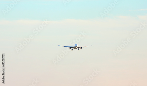 Passenger plane over the forest in the blue sky, the sun is shining. Transport, travel. High quality photo © Nataliia