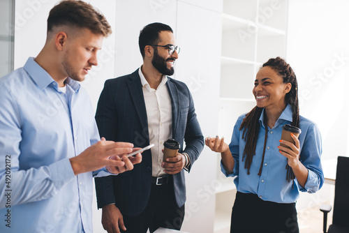 Cheerful team of male and female financial experts discussing planning for company cooperating and brainstorming , formally dressed group of happy employees communicating during coffee break
