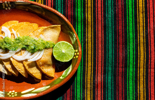 Background of the traditional Mexican basket tacos(Tacos de Canasta), made of potatoes, beans and pork rinds. Accompanied by a delicious and spicy green sauce with onion photo