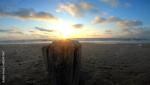 Sea breaker at sunset on the beach of the island of Ameland photo