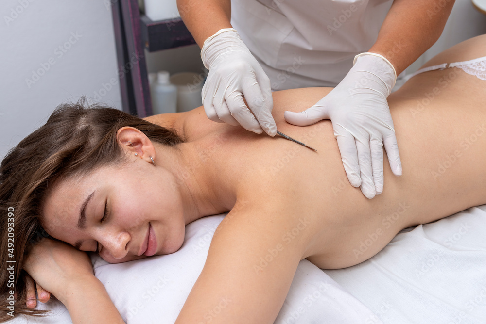 young woman in a beauty and spa center performing a beauty treatment for body and skin care with a dermaplaning technique