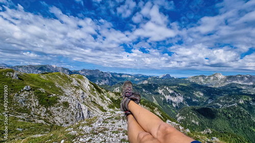 A female hiker having a break on the summit of Messnerin in Styria, Austria, Europe. The Hochschwab valley is full of lush green hills. Hiking trail, Wanderlust, Season. Sunny day. Freedom