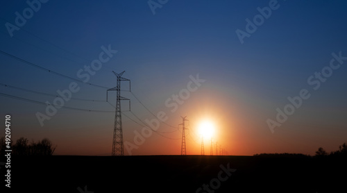 linia energetyczna na tle zachodzącego słońca © meegi