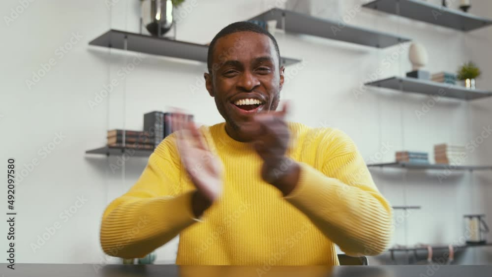 Young smiling man communicating by videoconference at home