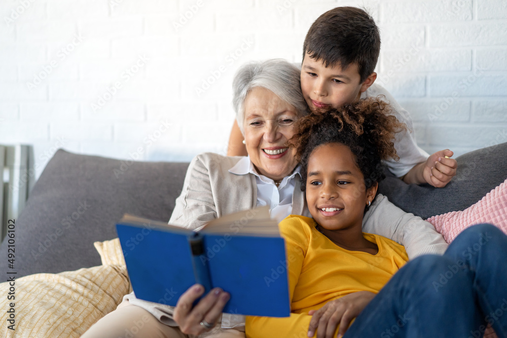Happy grandmother, nanny helping to mixed race grandchildren with study. Homeschooling concept Happy grandmother, nanny helping to mixed race grandchildren with study. Homeschooling concept