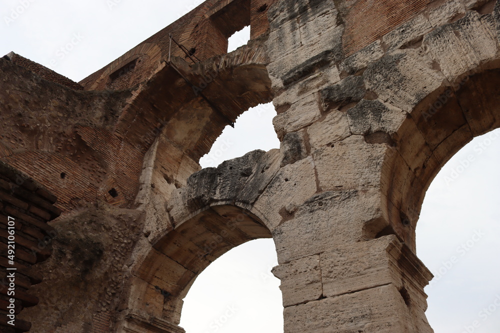 ROME, ITALY - February 05, 2022: Panoramic view of inside part of Colosseum in city of Rome, Italy. Cold and gray sky in the background. Macro photography of the arches.