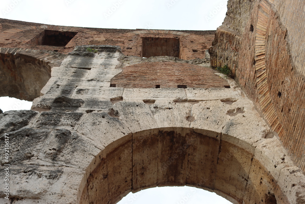 ROME, ITALY - February 05, 2022: Panoramic view of inside part of Colosseum in city of Rome, Italy. Cold and gray sky in the background. Macro photography of the arches.