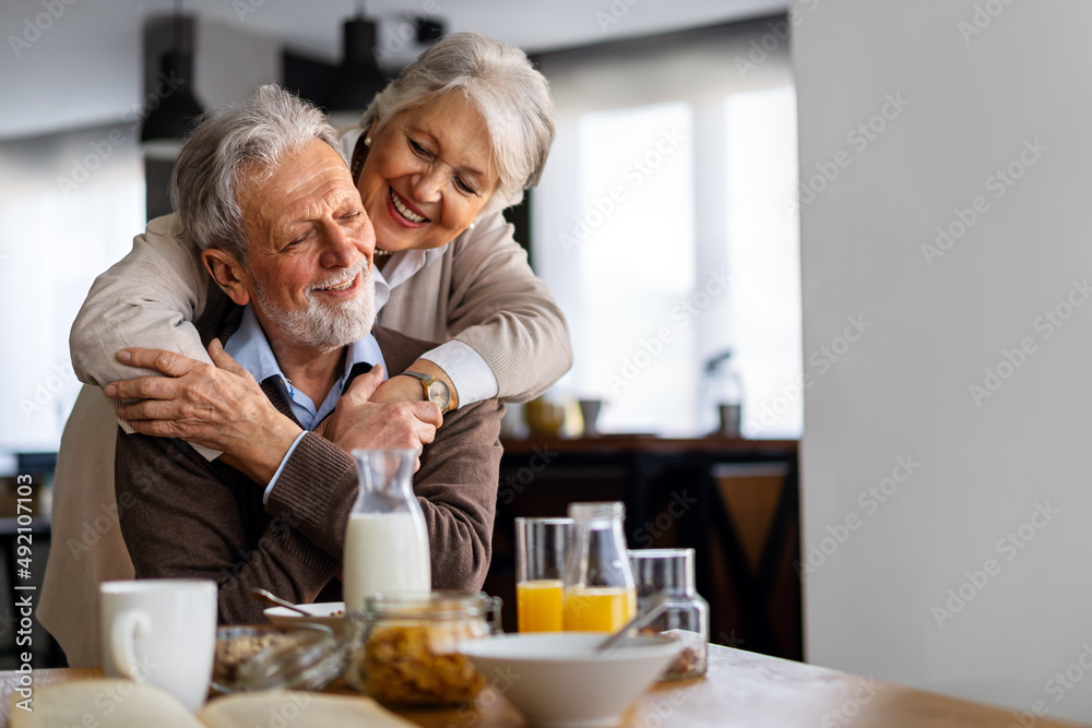 Beautiful senior couple having fun, smiling together while enjoying breakfast together