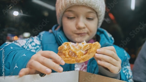 Child eat pizza cheese four. Close up of young girl woman mouth greedily eating pizza and chewing in outdoor restaurant. Kid children hands taking piece slice of hot tasty italian pizza from open box.