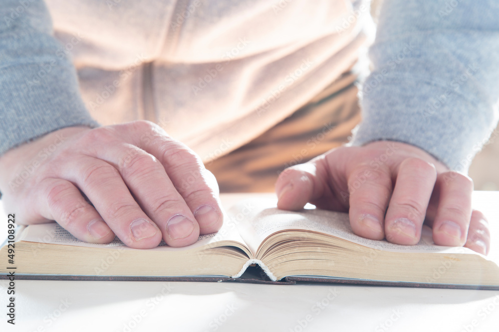 Paper books.A person reads paper books on a table. Paper books.A person reads paper books on a table.