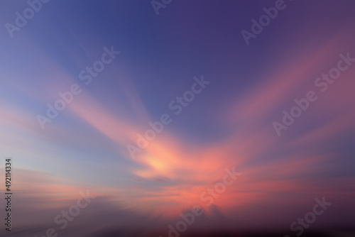 Blur sunset sky background. Blue sky with pink light background at sunrise. Sky cloud backgrounds. Sky clouds with bird or angel wings shaped. Backdrop for inspirational background.