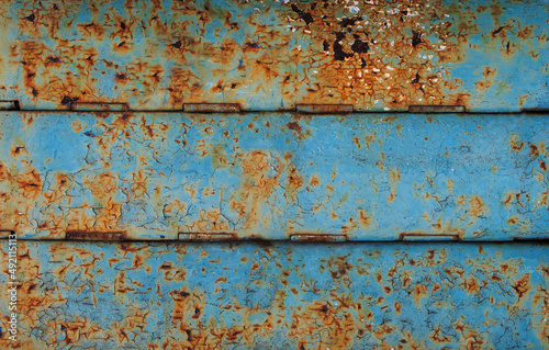 Old rusty metal blue surface. Bright blue and yellow grunge background with time-cracked paint
