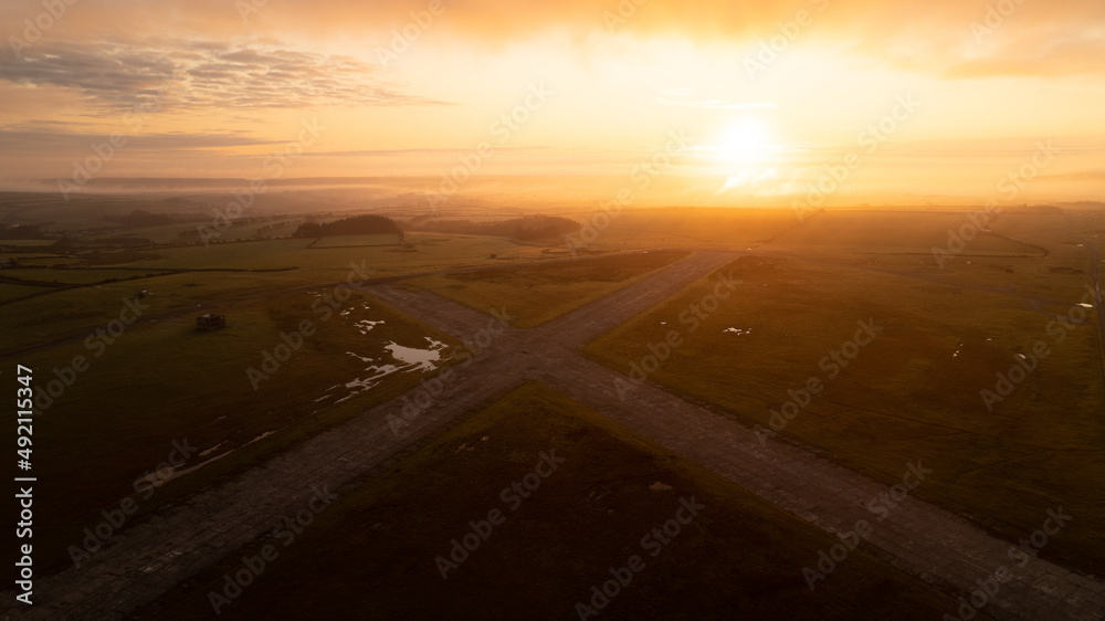 Orange sunrise over abandoned airfield