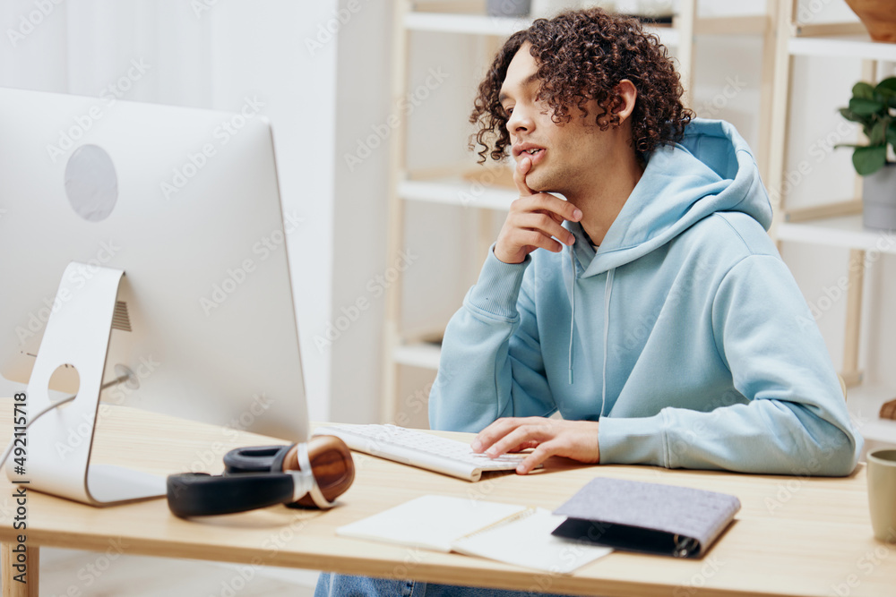 handsome guy in a blue jacket in front of a computer with phone technologies