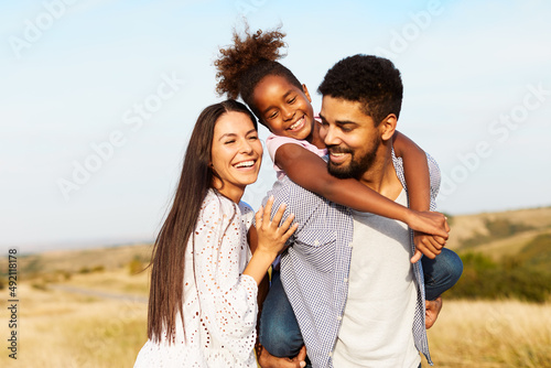 child daughter family happy mother father piggyback fun together girl cheerful field outdoor natur summer