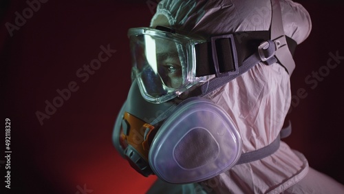 Man in protective costume suit, gas protect medical antibacterial antiviral spray paint mask. Doctor health worker in respirator. Concept health virus coronavirus epidemic. Radiation Nuclear war.