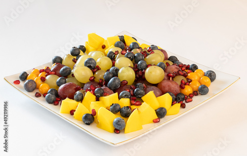 Mixed fruit salad on a plate on white background