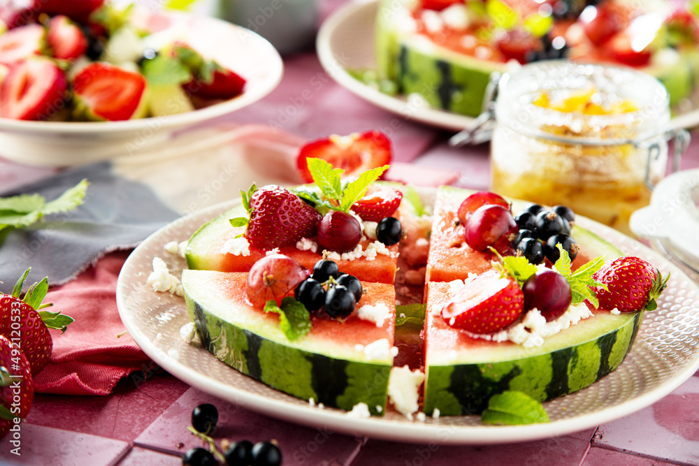 Fresh summer salad with berries and fruits on watermelon with feta cheese Fresh summer salad with berries and fruits on watermelon with feta cheese