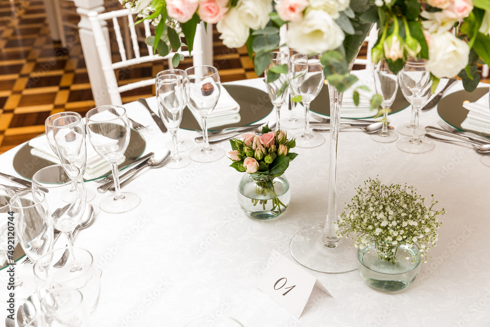 wedding table setting with flowers, cutlery and glasses