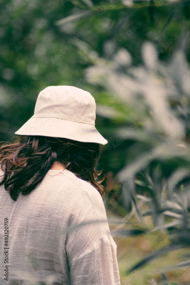 woman with white hat in an environment with plants