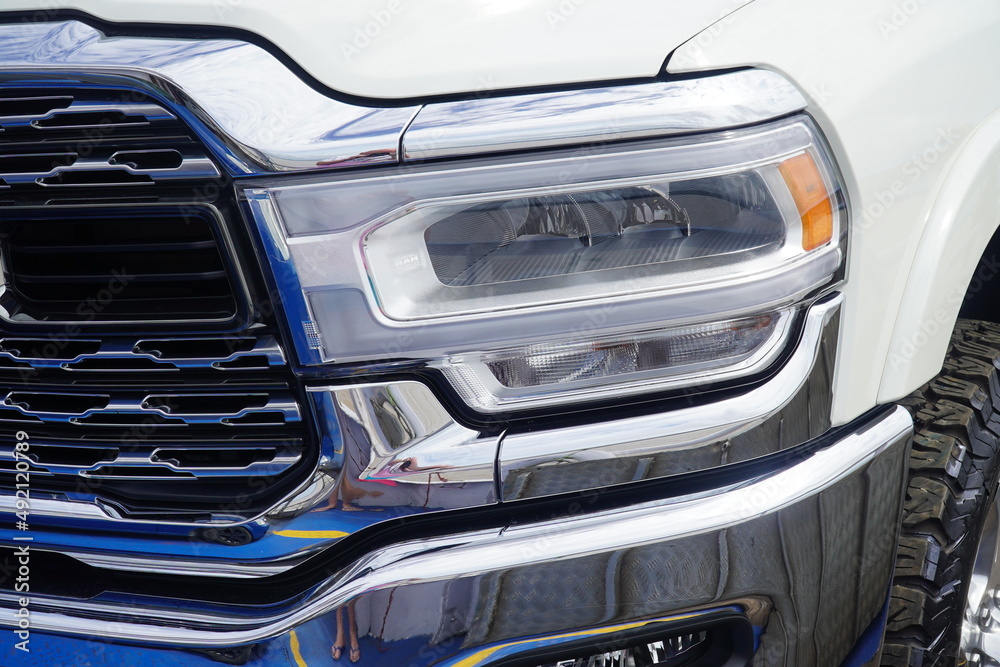 Radiator grille with headlight unit full of shiny chrome, white heavy pickup truck. - obrazy, fototapety, plakaty 