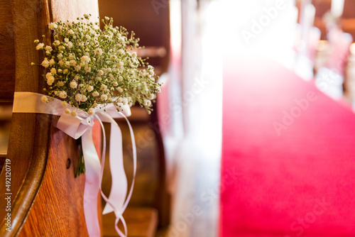 wedding bouquet on the bench with church red carpet walkway