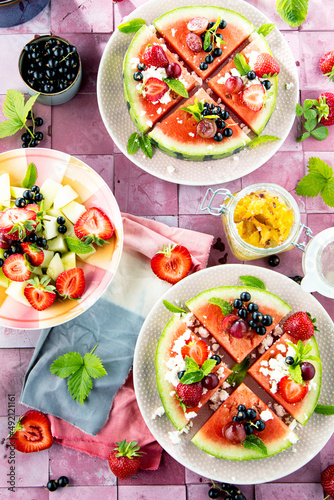 Fresh summer salad with berries and fruits on watermelon with feta cheese
