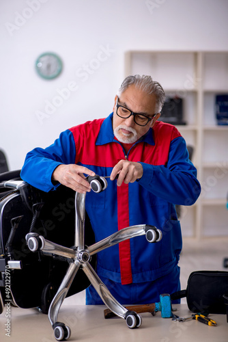 Old male repairman repairing office chair