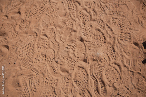 Fototapeta Naklejka Na Ścianę i Meble -  footprints of human shoes on red sand 