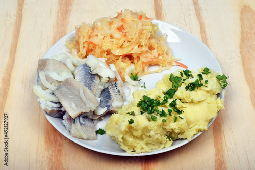 Herring with boiled potatoes, salad with parsleyn as polish traditional dinner photo
