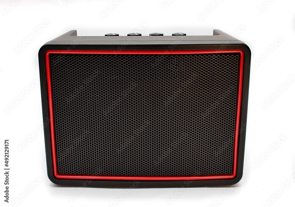 Głośnik bezprzewodowy bluetooth widziany z przodu prostokątny czarny z czerwoną ramką na baterie AA paluszki z pokrętłami u góry - obrazy, fototapety, plakaty 