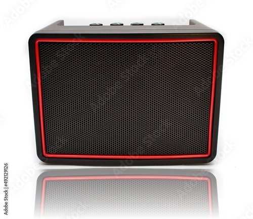Głośnik bezprzewodowy bluetooth widziany z przodu prostokątny czarny z czerwoną ramką na baterie AA paluszki z pokrętłami u góry
